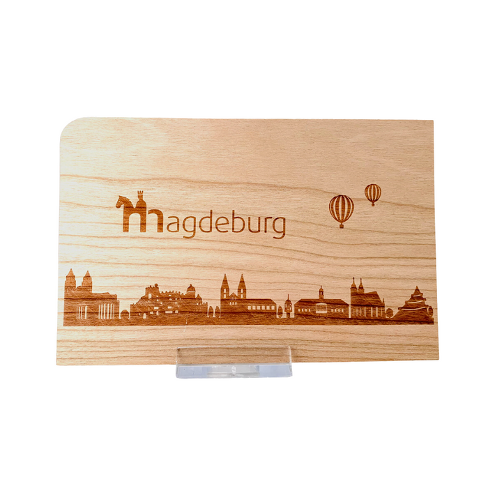 Holz-Grußkarte mit gravierter Skyline von Magdeburg, inkl. Heißluftballons im Hintergrund, erhältlich im Magdeburg-Shop als einzigartiges Souvenir.