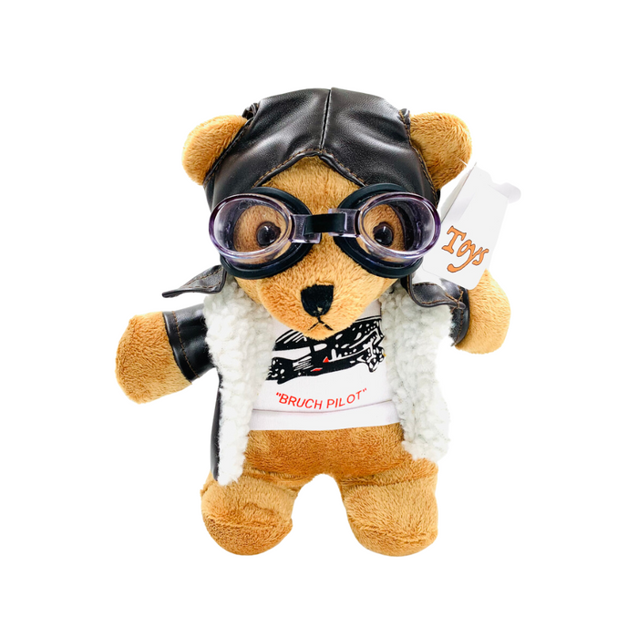 Plüschbär Hans der Bruchpilot im Fliegeroutfit mit Lederkappe und Schutzbrille, trägt ein T-Shirt mit der Aufschrift 'BRUCH PILOT'. Originelles Souvenir aus der Magdeburger Fliegergeschichte im magdeburg-shop.