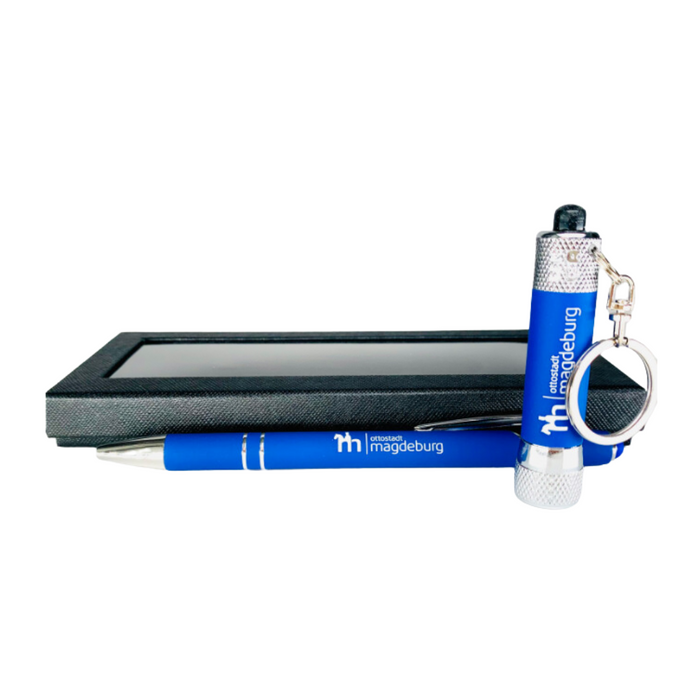 Geschenkset mit blauem Kugelschreiber und Minilampe, bedruckt mit 'ottostadt magdeburg' Logo, präsentiert in schwarzer Box — ideal als Merchandise aus Magdeburg.