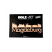 Aufkleber Holz-Skyline mit Schriftzug Magdeburg aus Holz, selbstklebend, vor schwarzem Hintergrund.