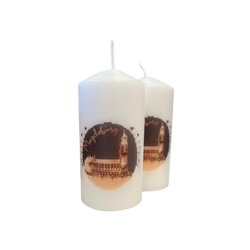 Zwei weiße Kerzen mit winterlichem Motiv des Magdeburger Doms. Die Kerzen zeigen ein Bild des Doms mit der Aufschrift 'Magdeburg', ideal als winterliche Dekoration oder Weihnachtsgeschenk.